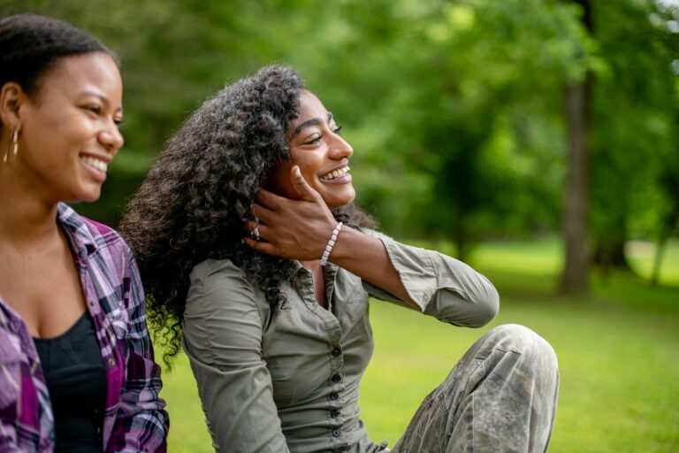Two smiling women in a park